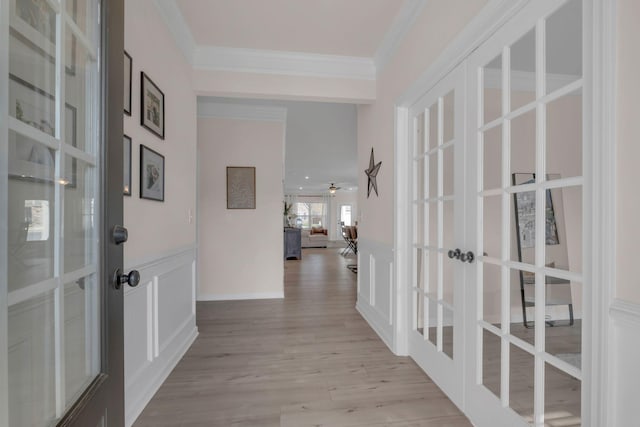 hall with french doors, light hardwood / wood-style floors, and ornamental molding