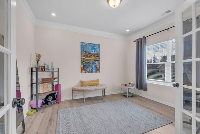 sitting room featuring ornamental molding and light hardwood / wood-style flooring