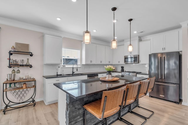 kitchen with white cabinetry, a center island, stainless steel appliances, and sink