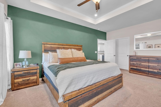 carpeted bedroom with ceiling fan, a raised ceiling, and crown molding