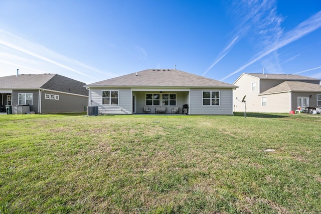 back of property featuring a lawn and central air condition unit