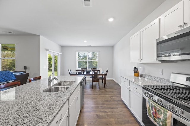 kitchen featuring appliances with stainless steel finishes, white cabinetry, dark wood-type flooring, and sink