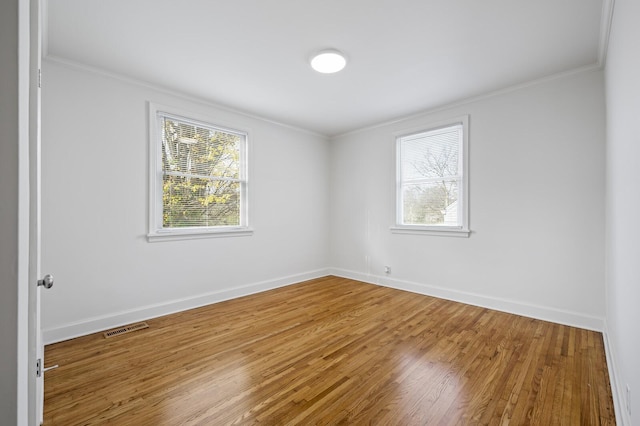 unfurnished room with wood-type flooring and ornamental molding