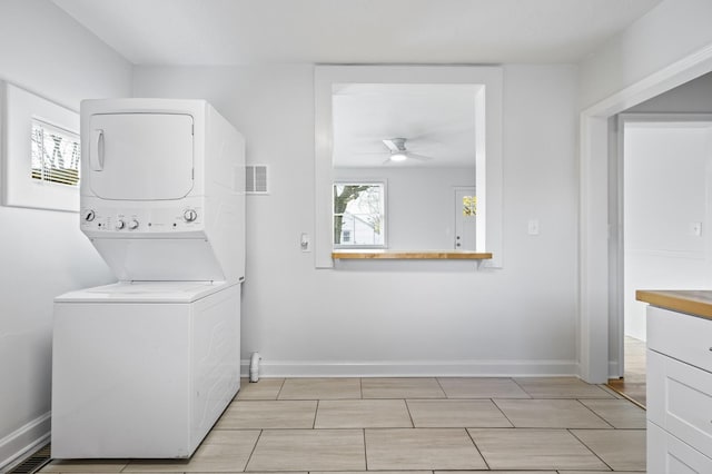 laundry room with ceiling fan and stacked washer and clothes dryer