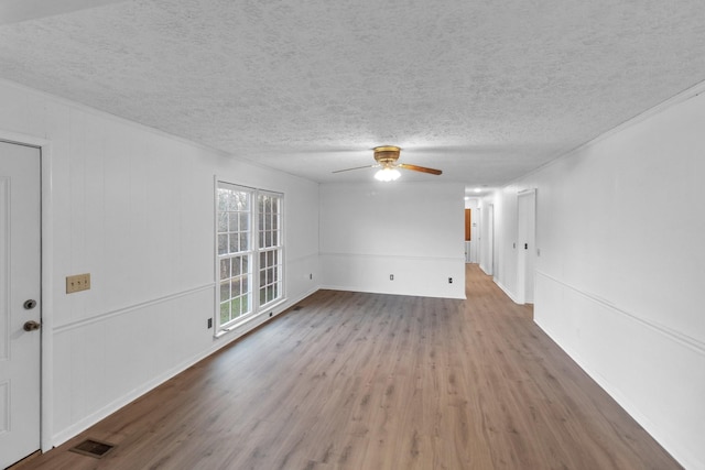 empty room with a textured ceiling, hardwood / wood-style flooring, and ceiling fan