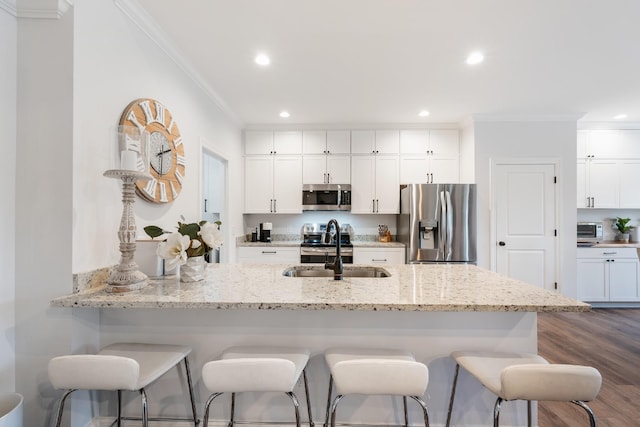 kitchen featuring crown molding, dark hardwood / wood-style flooring, white cabinets, and appliances with stainless steel finishes