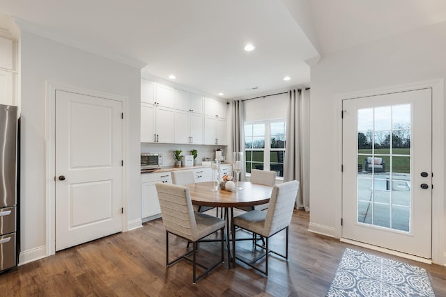 dining space featuring light hardwood / wood-style floors, crown molding, and a healthy amount of sunlight