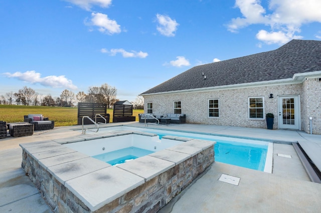 view of pool with an in ground hot tub, an outdoor living space, and a patio area