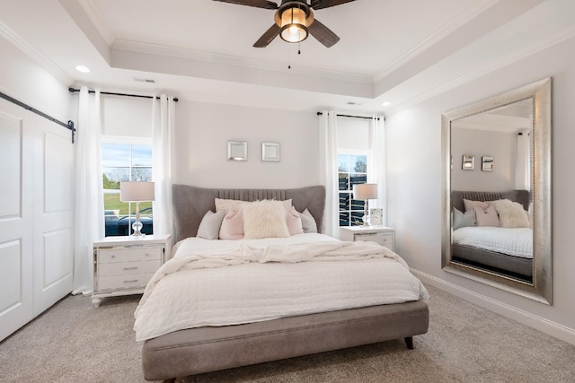 bedroom featuring ceiling fan, crown molding, light carpet, and a tray ceiling