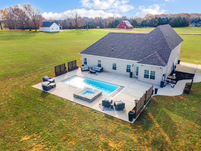 rear view of property featuring an outdoor living space, a pool with hot tub, a patio area, and a lawn