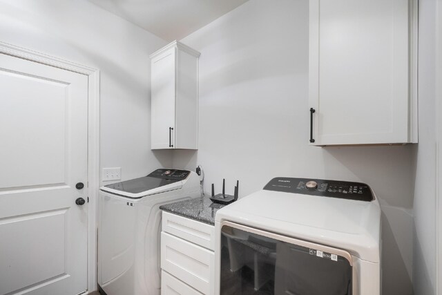 laundry area with washer and clothes dryer and cabinets