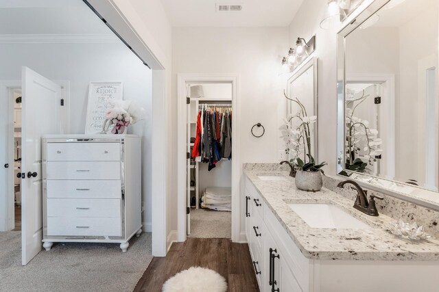 bathroom with hardwood / wood-style floors, vanity, and crown molding