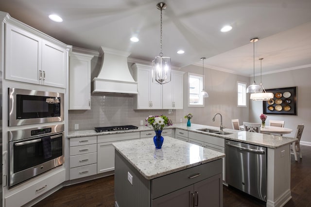 kitchen featuring a center island, white cabinets, sink, custom range hood, and stainless steel appliances