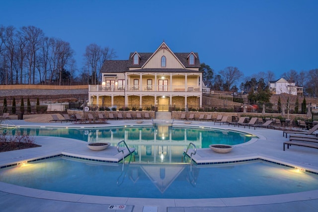 pool at dusk with a patio area