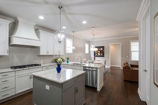 kitchen with premium range hood, hanging light fixtures, a kitchen island, dark hardwood / wood-style flooring, and stainless steel appliances