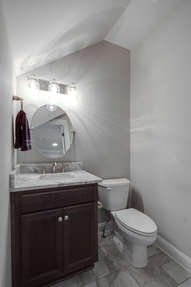 bathroom with vanity, toilet, and lofted ceiling