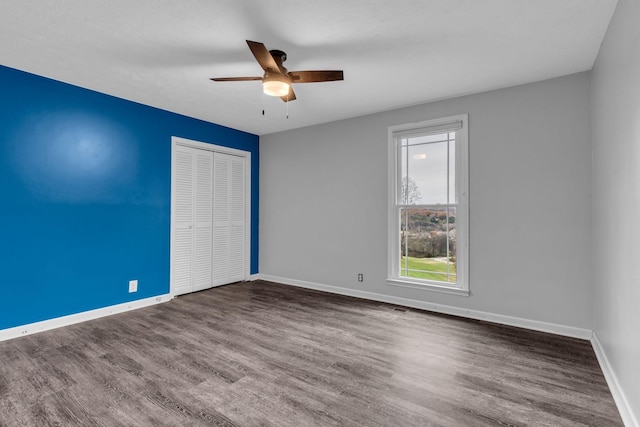 empty room featuring ceiling fan and dark hardwood / wood-style flooring