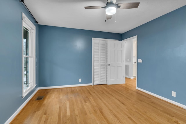 unfurnished bedroom with ceiling fan, a closet, and light hardwood / wood-style flooring