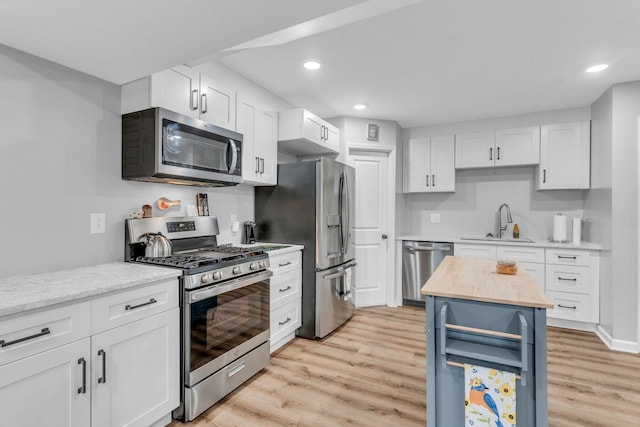 kitchen featuring sink, white cabinets, stainless steel appliances, and light wood-type flooring