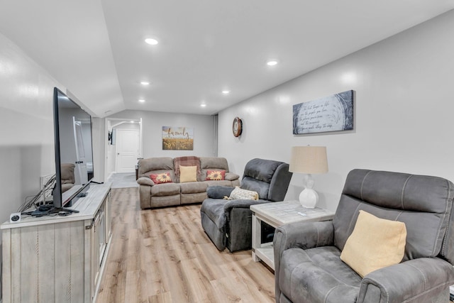 living room with light hardwood / wood-style flooring and vaulted ceiling