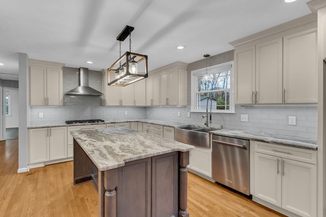 kitchen with wall chimney exhaust hood, light hardwood / wood-style floors, dishwasher, and decorative light fixtures