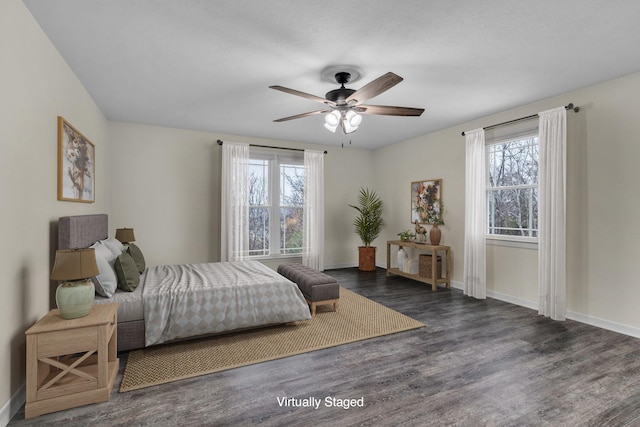 bedroom featuring multiple windows, dark wood-type flooring, and ceiling fan