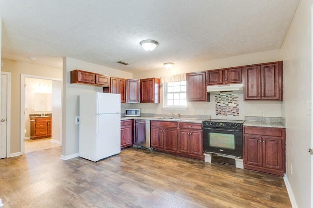 kitchen with a textured ceiling, sink, dark wood-type flooring, and white appliances