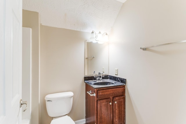 bathroom featuring vanity, a textured ceiling, and toilet