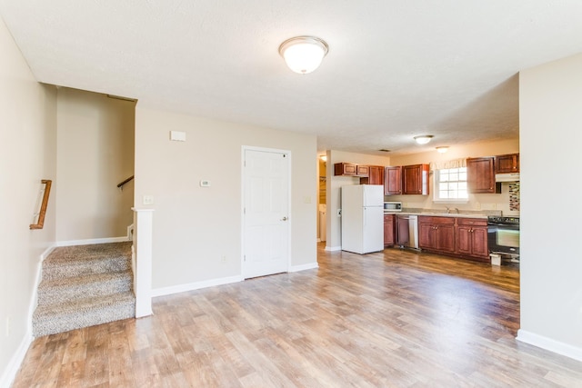 kitchen featuring sink, light hardwood / wood-style flooring, a textured ceiling, and appliances with stainless steel finishes