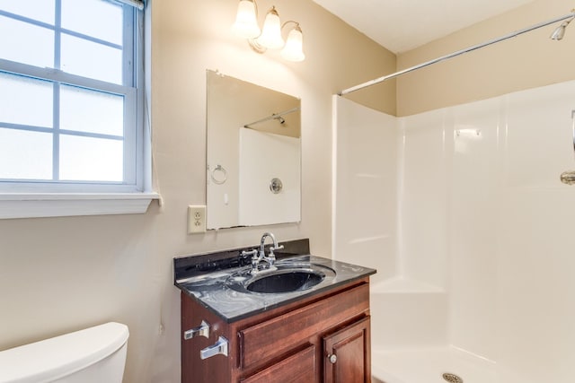 bathroom featuring vanity, toilet, and walk in shower