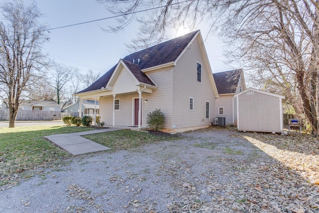 view of property featuring a shed, a front lawn, and central air condition unit