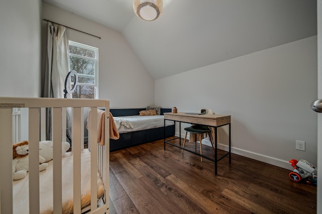 bedroom featuring a nursery area, dark hardwood / wood-style floors, and lofted ceiling