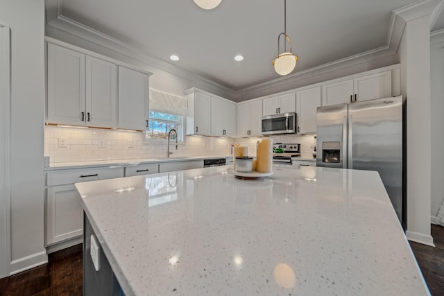 kitchen with light stone countertops, appliances with stainless steel finishes, sink, dark hardwood / wood-style floors, and hanging light fixtures