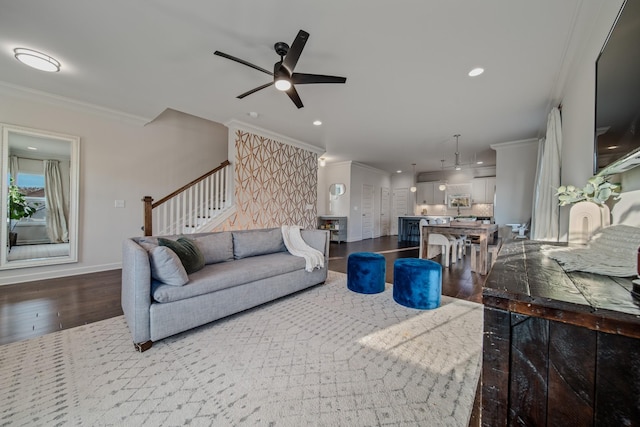 living room featuring hardwood / wood-style flooring, ceiling fan, and crown molding