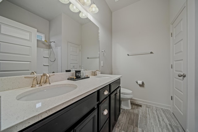 bathroom featuring a shower, wood-type flooring, vanity, and toilet