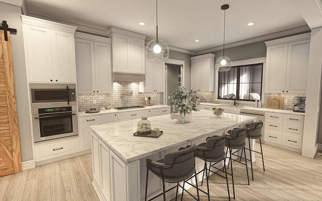 kitchen featuring white cabinets, a center island, a kitchen bar, and appliances with stainless steel finishes