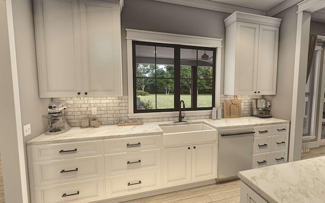 kitchen featuring backsplash, white cabinetry, sink, and light stone counters