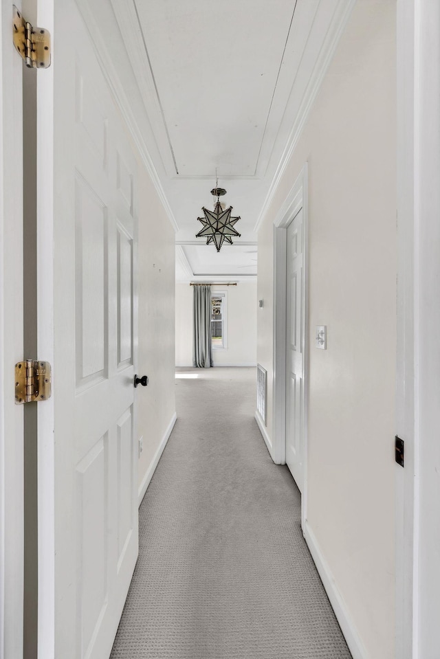 hall with light colored carpet and crown molding