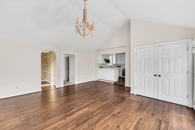 unfurnished living room featuring a chandelier, lofted ceiling, and dark hardwood / wood-style floors