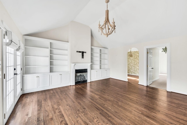 unfurnished living room featuring vaulted ceiling, dark hardwood / wood-style flooring, built in shelves, and a notable chandelier