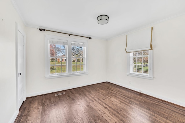 spare room featuring ornamental molding and dark hardwood / wood-style floors