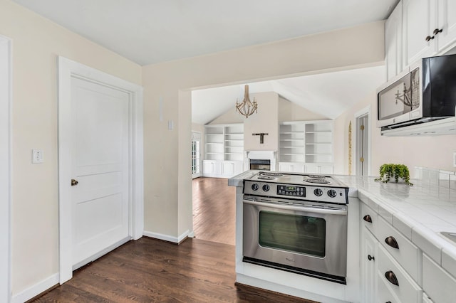 kitchen featuring tile counters, appliances with stainless steel finishes, dark hardwood / wood-style flooring, white cabinets, and an inviting chandelier