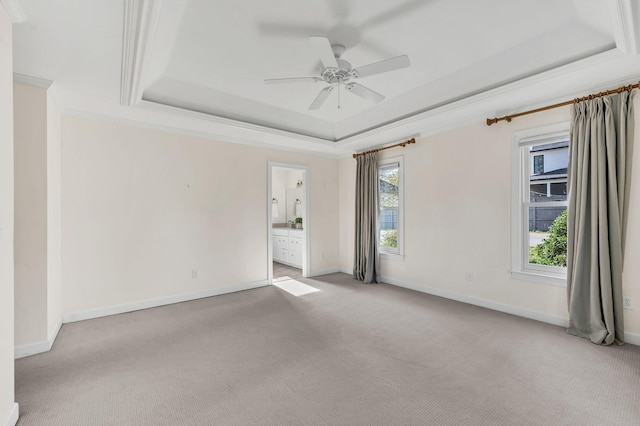 spare room with ceiling fan, light carpet, a wealth of natural light, and a tray ceiling