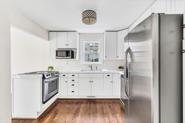 kitchen featuring sink, stainless steel appliances, dark hardwood / wood-style floors, and white cabinetry