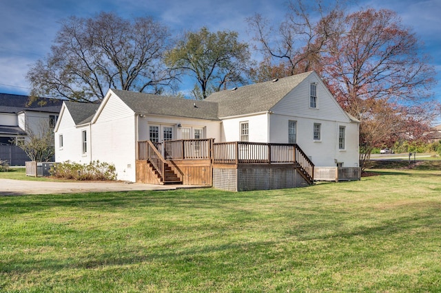 rear view of house with a yard, a wooden deck, and central AC unit