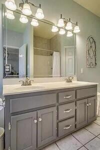 bathroom with a shower with shower curtain, vanity, and tile patterned floors