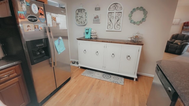 kitchen with white cabinetry, stainless steel appliances, and light wood-type flooring