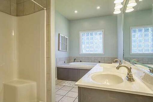 bathroom featuring tile patterned floors, a tub, and vanity