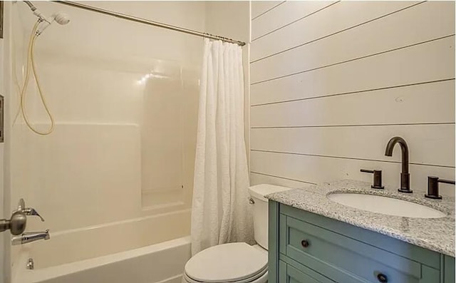 full bathroom with wood walls, shower / tub combo with curtain, vanity, and toilet