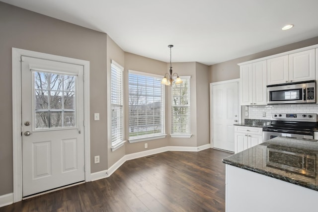 kitchen with white cabinets, pendant lighting, appliances with stainless steel finishes, and a chandelier